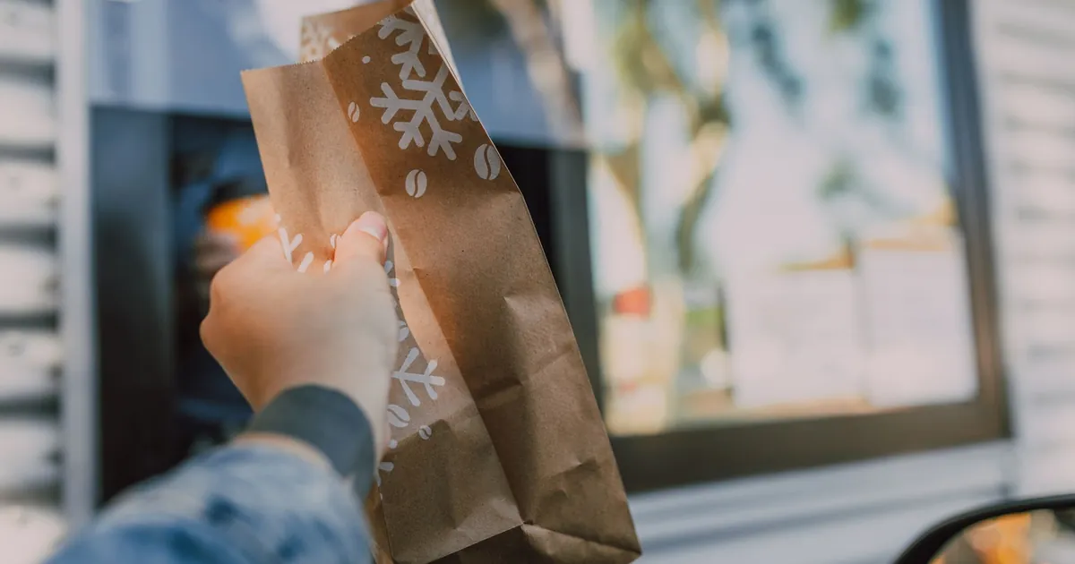 A paper takeout bag handed out through a drive-thru window
